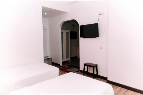a room with two beds and a flat screen tv at Ridel Sunset Hotel in Kota Bharu