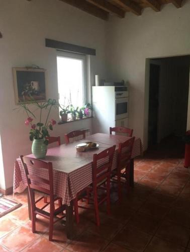 une cuisine avec une table avec des chaises et un réfrigérateur dans l'établissement La Tuilerie 1860, à Biaudos