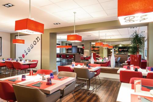 a dining room with tables and chairs and a restaurant at Hotel Ibis Milano Malpensa in Cardano al Campo