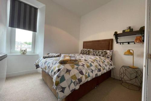 Schlafzimmer mit einem Bett und einem Fenster in der Unterkunft Rosevale Apartment in Hawick