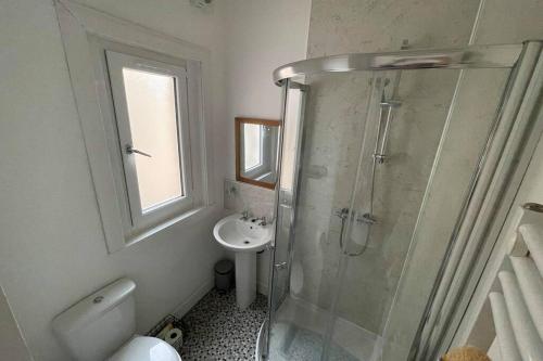 ein Bad mit einer Dusche und einem Waschbecken in der Unterkunft Rosevale Apartment in Hawick