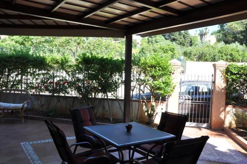 eine Terrasse mit einem Tisch, Stühlen und einem Zaun in der Unterkunft Villa Giusy 2 appartamenti indipendenti a locazione turistica breve -G&P HOLIDAY HOME in Valderice