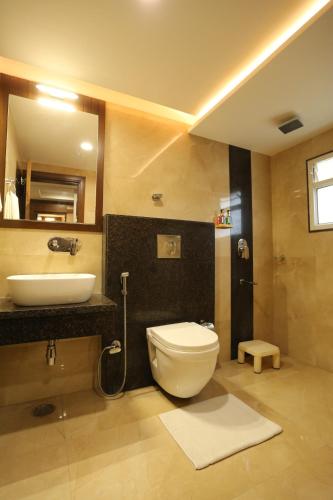 a bathroom with a white toilet and a sink at Alba Premier, Indore in Indore