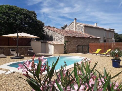 une cour avec une piscine et une maison dans l'établissement MAISON BOURGUES, à Lioux