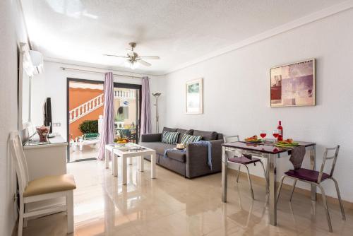 a living room with a couch and a table at Tenerife South Apartments in Playa de las Americas