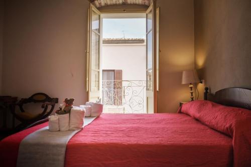 a bedroom with a large red bed with a window at Domo Sa Barra in SantʼAntìoco