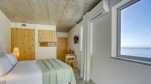a bedroom with a bed and a window at Socalco Nature Calheta in Calheta