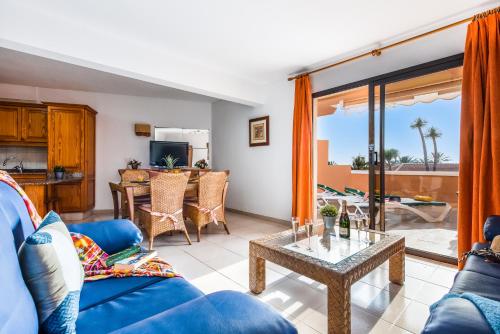 a living room with a blue couch and a table at Tenerife South Apartments in Playa de las Americas