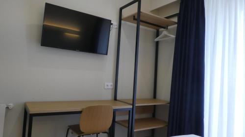 a room with a desk and a tv on a wall at Plaza Pombo B&B - Hostal in Santander