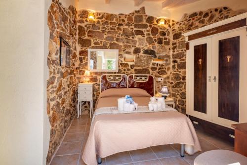 a room with two beds and a stone wall at Domo Sa Barra in SantʼAntìoco