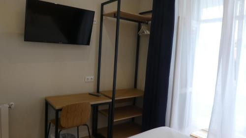 a room with a desk and a tv on a wall at Plaza Pombo B&B - Hostal in Santander