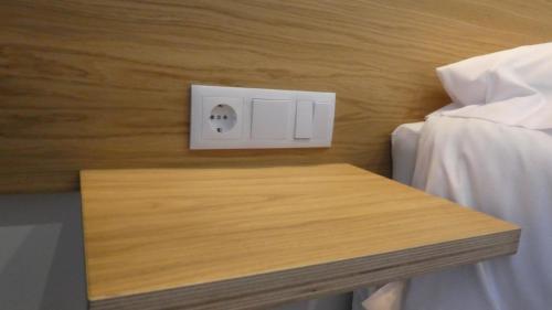 a light switch on a wall next to a bed at Plaza Pombo B&B - Hostal in Santander