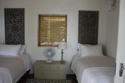 a bedroom with two beds and a window at Ashbourne Country Escape Hazyview in Hazyview