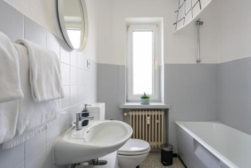a white bathroom with a sink and a toilet at CASSEL LOFTS - Komfortable Wohnung für 4 - nahe SMA & Fulda in Niestetal