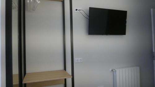 a flat screen tv hanging on a white wall at Plaza Pombo B&B - Hostal in Santander