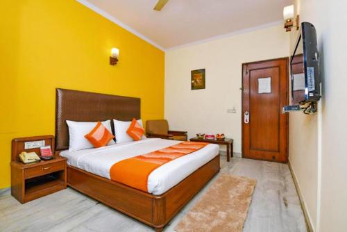 a bedroom with a bed and a flat screen tv at The Beaufort Inn in New Delhi