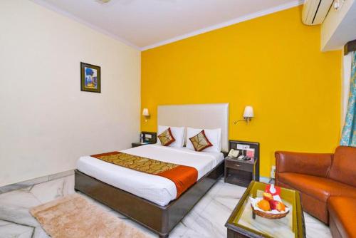 a hotel room with a bed and a couch at The Beaufort Inn in New Delhi