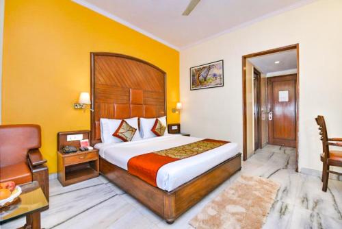 a hotel room with a bed and a chair at The Beaufort Inn in New Delhi