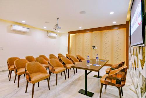 a conference room with chairs and a table and a screen at The Beaufort Inn in New Delhi