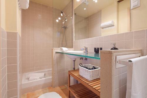 a bathroom with a sink and a mirror and a tub at Friendly Rentals Santa Monica in Barcelona
