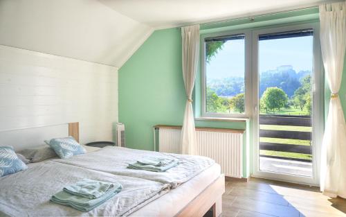 een slaapkamer met een bed en een groot raam bij Deerwood Villa-Modern cozy apartment with castle view in Bled