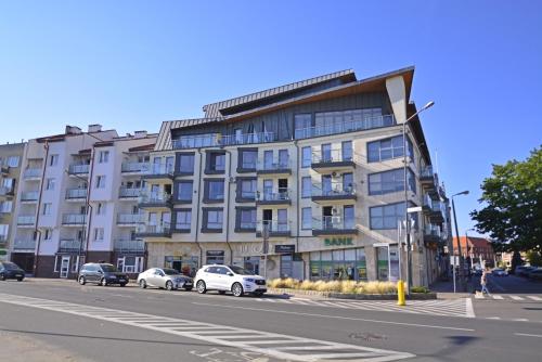 a building on a street with cars parked in front of it at Villa Concha-Apartamenty Bryza-Parking in Świnoujście
