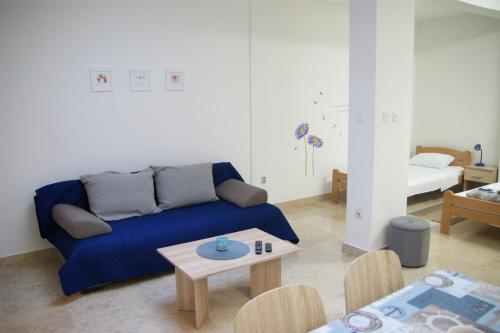 a living room with a blue couch and a table at APARTMAN IVANA in Pula