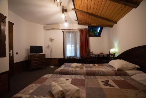 a hotel room with two beds and a television at B&B Casa Mica Guesthouse in Bucharest