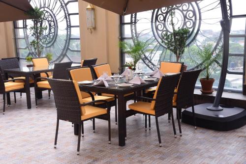 a dining room with a table and chairs and windows at Best Western Premier Hotel Gulberg Lahore in Lahore