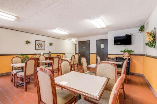 a dining room with tables and chairs and a flat screen tv at Econo Lodge Eden in Eden