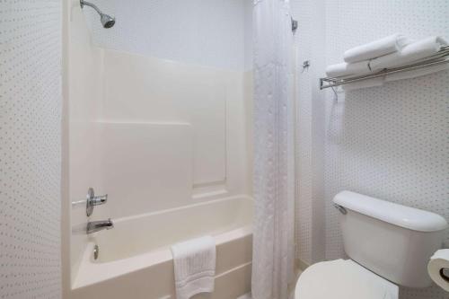 a white bathroom with a toilet and a shower at Rodeway Inn Urbana Champaign University Area in Champaign
