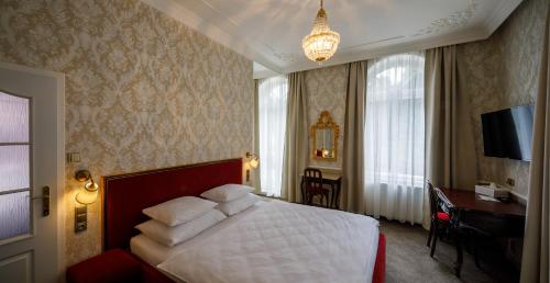 a bedroom with a large bed and a large window at Villa Basileia Riverside in Karlovy Vary