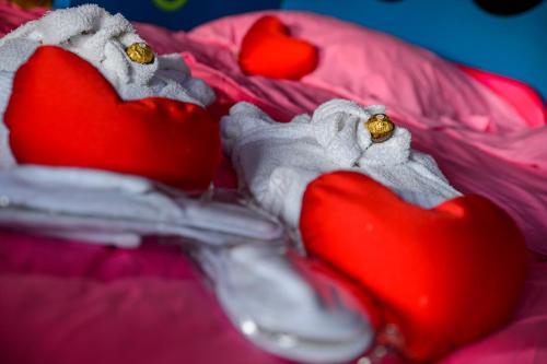 a pair of red hearts on a pink blanket at Hotel Motel Residence S in Front