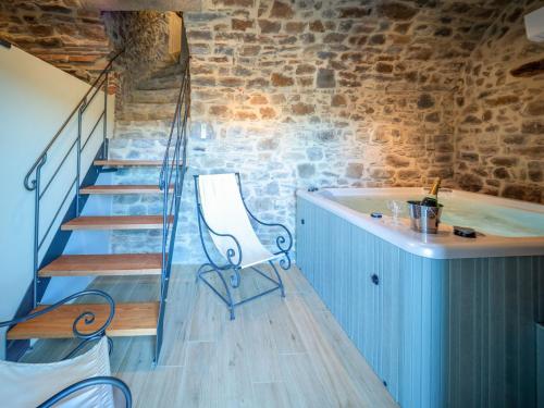 a room with a staircase and a chair and a tub at Holiday Home La Suite del Benessere by Interhome in Seggiano