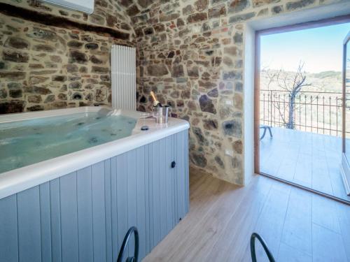 a bathroom with a hot tub in a stone wall at Holiday Home La Suite del Benessere by Interhome in Seggiano
