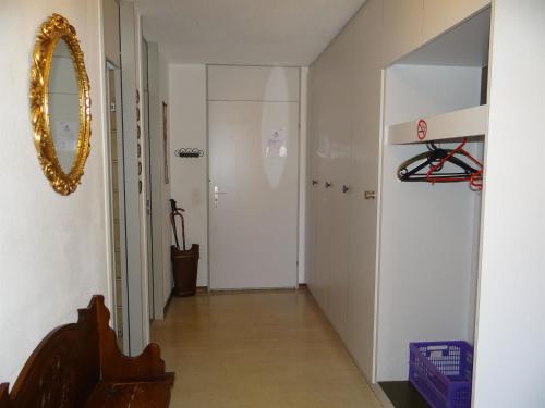einen Flur mit Tür und Spiegel in der Unterkunft Apartment Sunnmatt Süd Wohnung 831 by Interhome in Engelberg