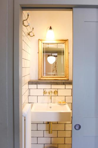 a bathroom with a sink and a mirror at The Bull Inn in Totnes