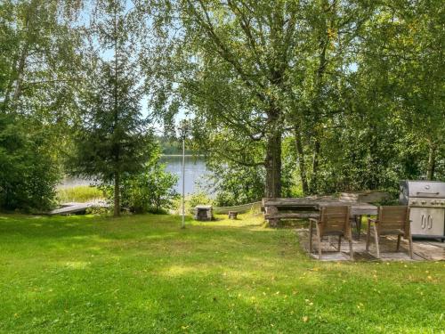 a picnic table in the grass next to a lake at Holiday Home Matkonranta by Interhome in Kerimäki