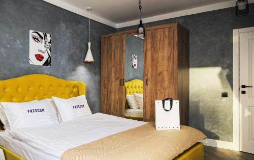 ein Schlafzimmer mit einem Bett mit einem gelben Kopfteil in der Unterkunft Freedom apartments in city center in Kiew