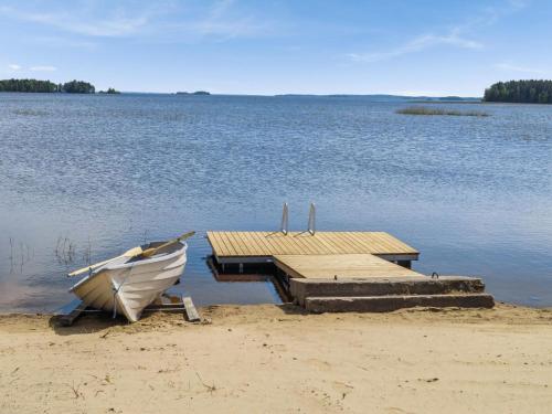 a boat sitting on the beach next to a dock at Holiday Home Huvilakoti 2 by Interhome in Puromäki