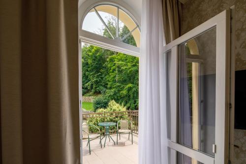 an open door to a patio with a table and chairs at Villa Basileia Riverside in Karlovy Vary