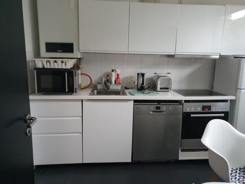 a white kitchen with a sink and a microwave at Bei Barbara in Wittingen