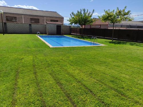 un gran patio con una piscina en el césped en Casa San Miguel en Huércanos