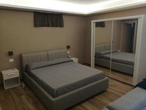 - une chambre avec un lit et un grand miroir dans l'établissement Etna relax, à Zafferana Etnea