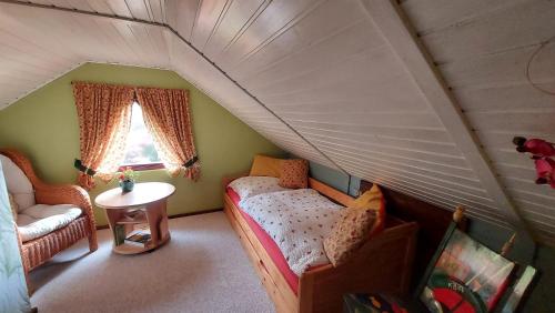 a attic room with a bed and a window at Ferienhaus Julchen Samtens in Samtens