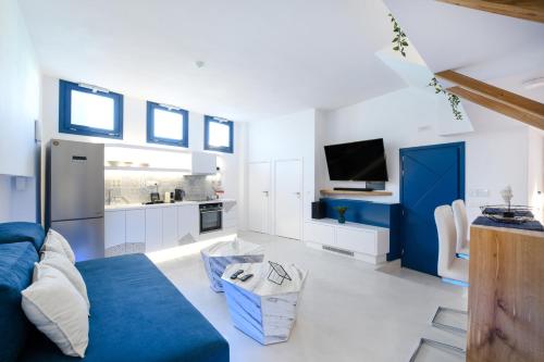 a living room with a blue couch and a kitchen at Blue White Residence in Monolithos