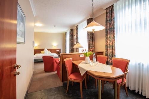 a hotel room with a table and chairs and a bed at Aparthotel Hohenzollern in Bad Kissingen
