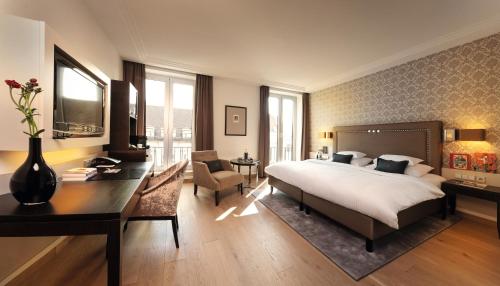 Habitación de hotel con cama, escritorio y escritorio. en Hotel Maximilian’s en Augsburg