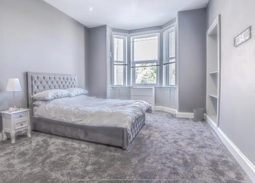 biała sypialnia z łóżkiem i oknem w obiekcie Beautiful modern open plan living with Hot Tub w mieście Kelty