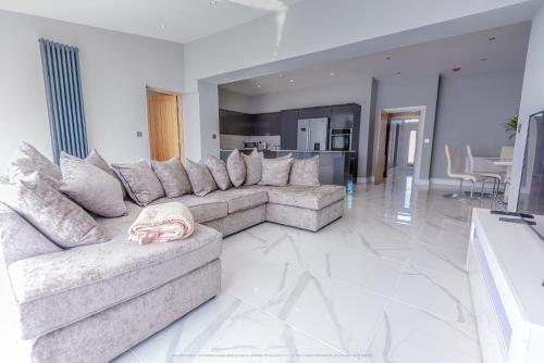 a large living room with a couch and a table at Beautiful modern open plan living with Hot Tub in Kelty